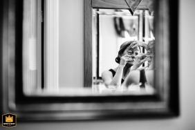 In a private residence in Saratoga, CA, the bride focuses on an intimate pre-ceremony moment, carefully working on her eye makeup as she prepares for her wedding day.